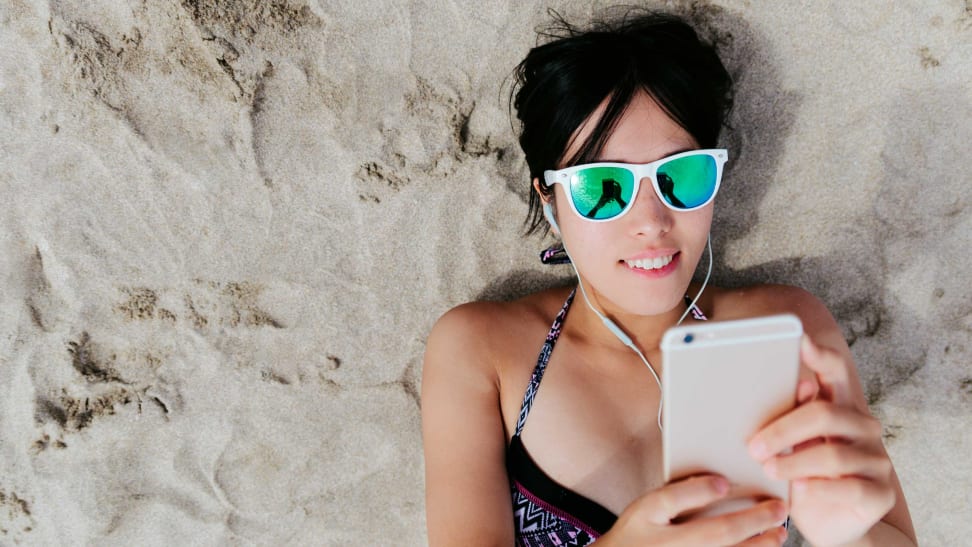 A person at the beach using their smartphone