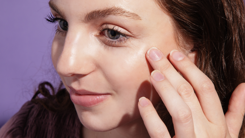 A woman showing off applied Saie Beauty.