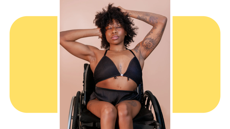 Model wearing black bra and underwear set with hands in their hair while sitting in wheelchair.