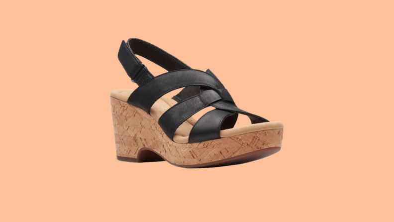 A high wedge sandal with black leather straps.
