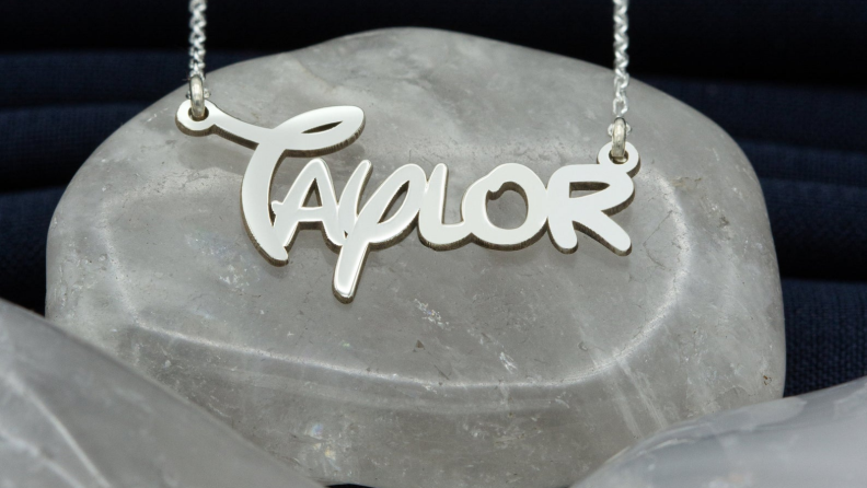 A silver necklace that reads 