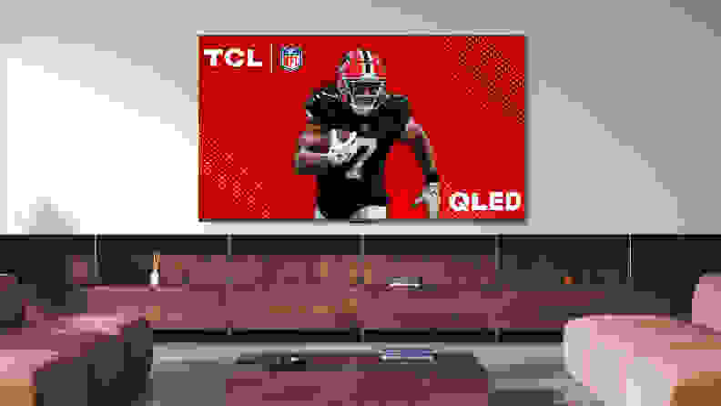 The TCL Q6 LED TV displaying a professional football player in a modern living room