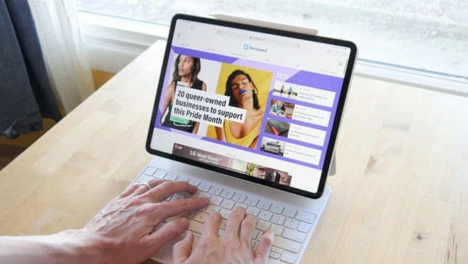 A person types on a keyboard attached to an iPad.