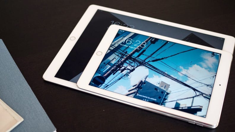 Two differently sized iPads sit on a table.