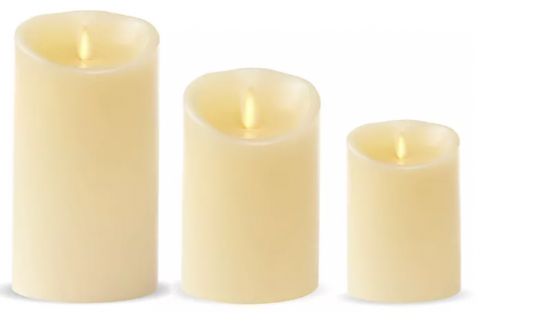 Three flameless candles of various sizes against a white background.