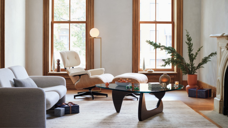 A white leather and natural wood Eames chair staged in a living area.