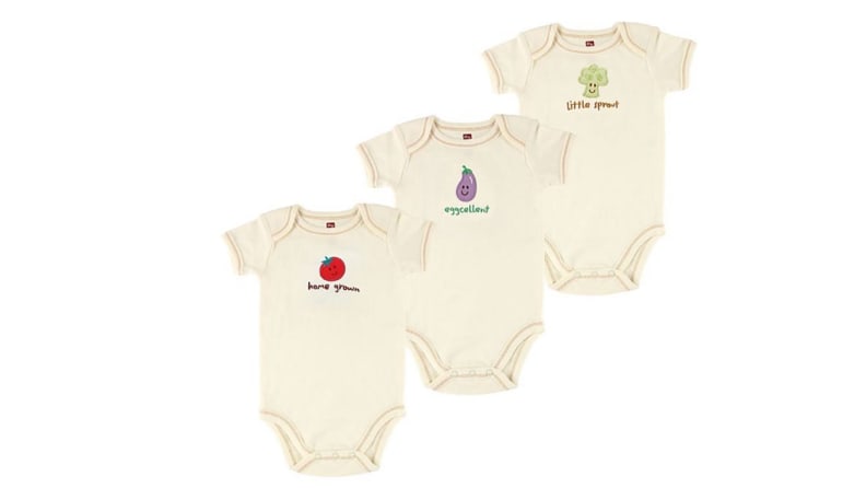 Three cream colored infant onesies with fruits and vegetable on front.