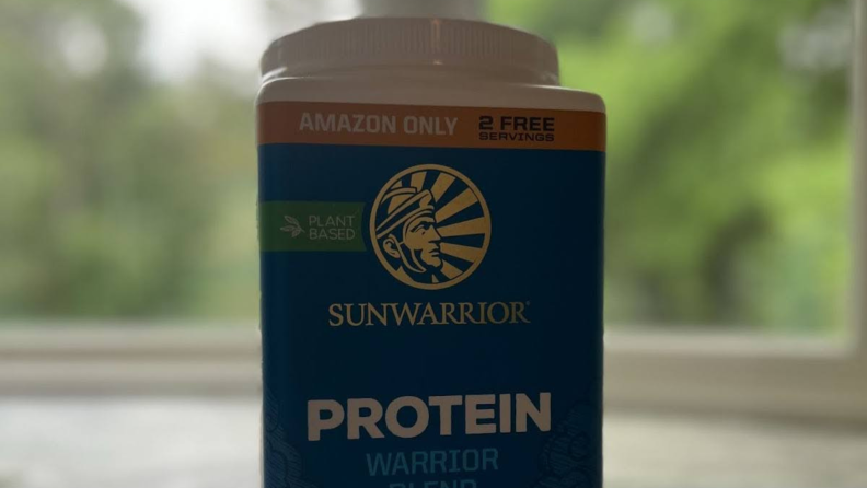 Close-up of the top half of the blue, white, and brown packaging of Sunwarrior's Protein Warrior Blend