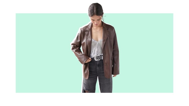 A model wears a brown leather jacket.