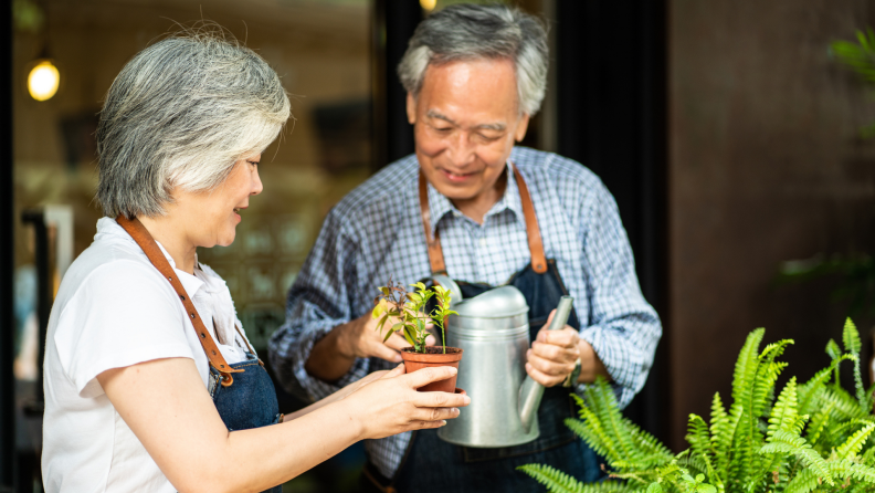 Two people water plants at home.