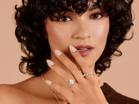 An image of a woman with two diamond rings on her fingers, one on her ring finger.