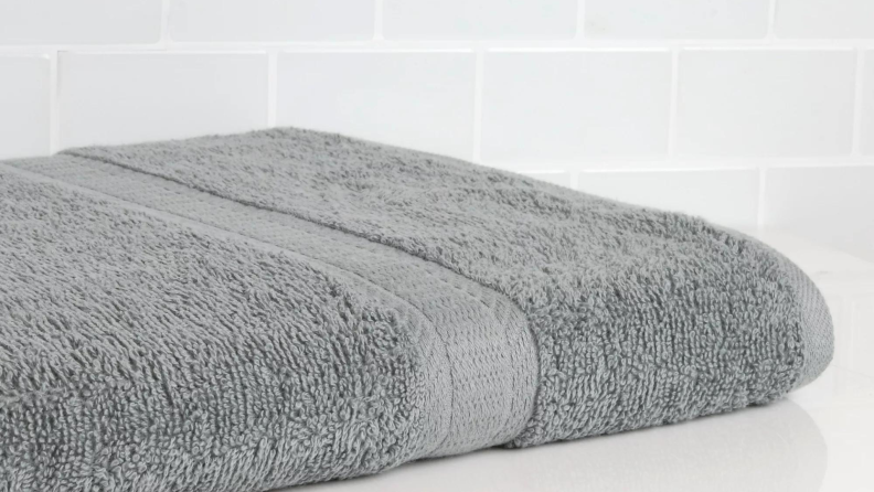 A gray towel laying on a bathroom counter.