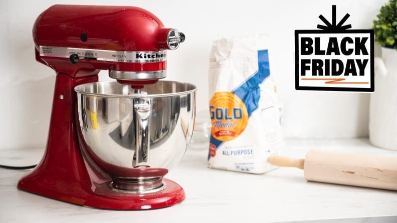 A red KitchenAid stand mixer on a kitchen counter next to baking supplies