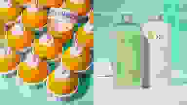 左边，蓝色表面的柠檬形状的容器，里面装满了润肤霜。在右边，绿色和白色的产品瓶子前面的绿色瓷砖背景。