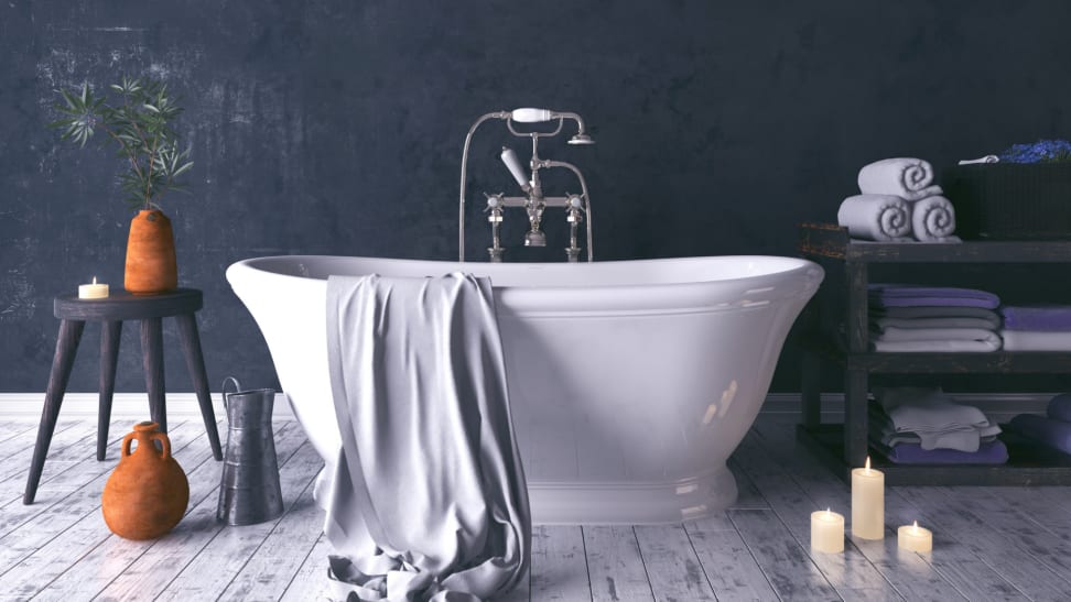 A rustic and dark bathroom with a white standalone tub.