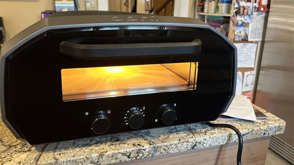 The Ooni Volt 12 pizza oven sitting on top of granite countertop.