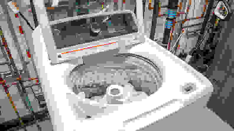 An overhead shot of a GE washer with the lid flipped up and the drum filled with towels.