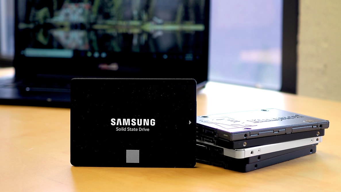 A 2.5" SATA SSD standing vertically in front of a stack of more SSDs