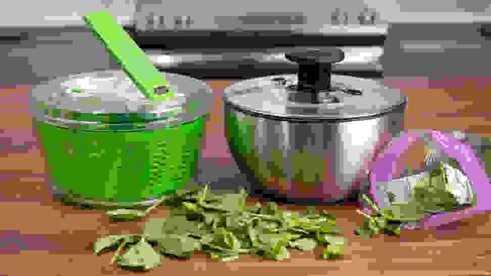 The Zyliss Dry and OXO Steel salad spinners sit side by side on a kitchen counter.