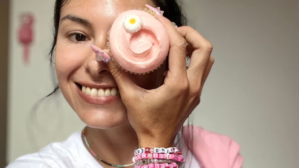 The author holding a cupcake with one hand.