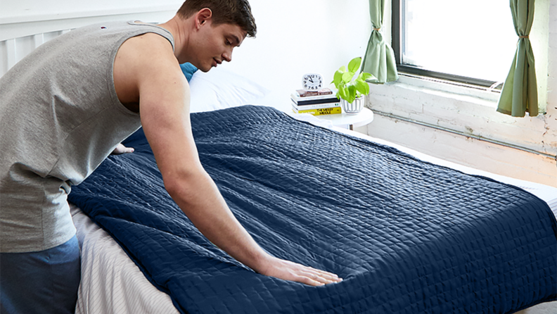 Man lying a Gravity Blanket on a bed