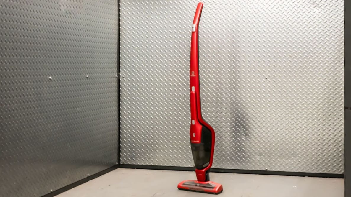 A red Electrolux Ergorapido standing upright in front of  a metallic background.