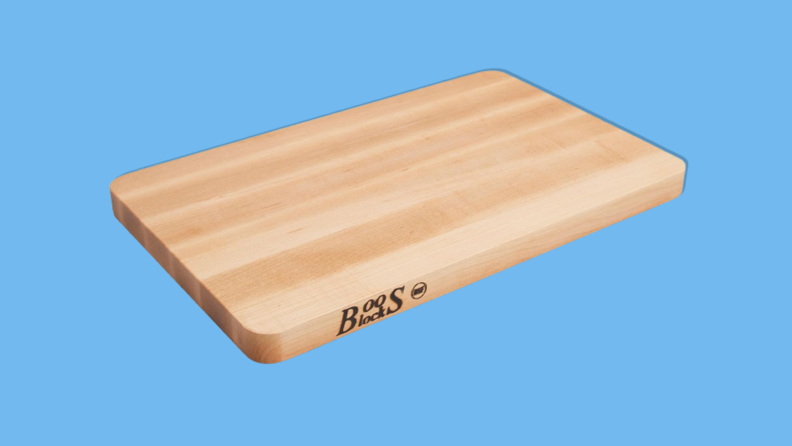 John Boos Block Chop-N-Slice maple wood reversible cutting board on blue background.