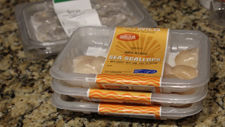 A stack of pre-portioned containers filled with seafood.