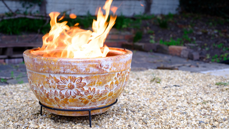 A clay outdoor fire pit in back garden in cold autumn evening.