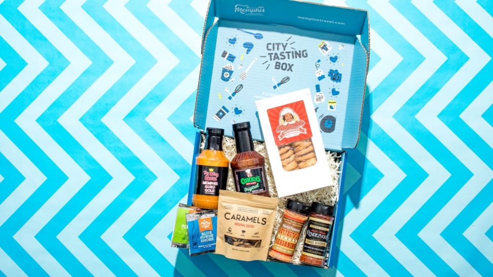 City Tasting Box's Memphis-themed box, open, showcasing all of the food products inside, on a blue zigzag pattern