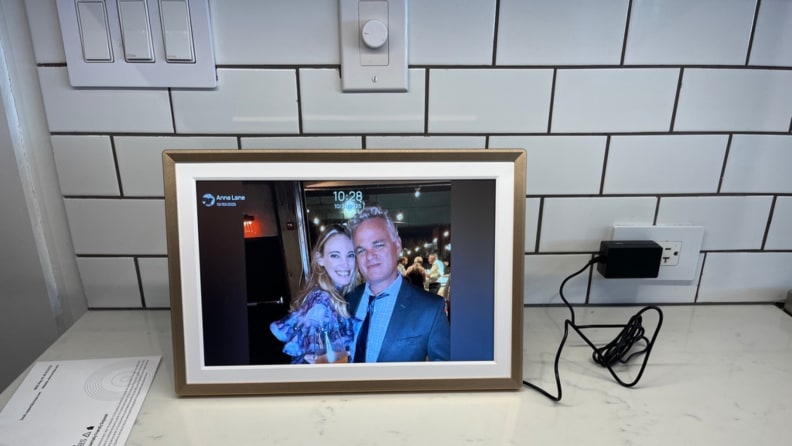 A man and woman embrace in a digital photo frame