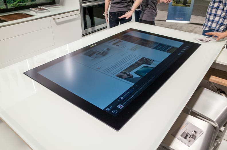 The "social table" is defined by a gigantic Windows 8 tablet screen, which can be used to cast webpages and videos to the backsplash displays.