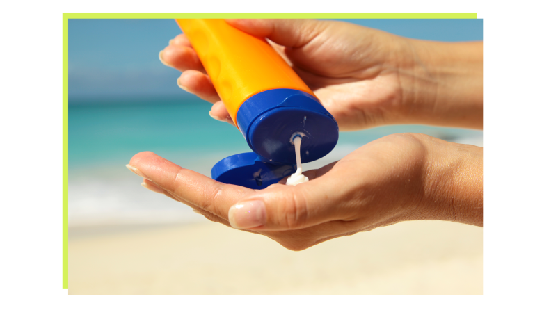 A person's hand holding a bottle of sunscreen and squeezing it into their other hand at the beach.