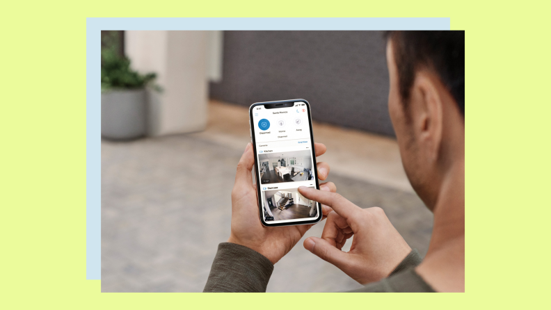 A person checks security system notifications on their smartphone.