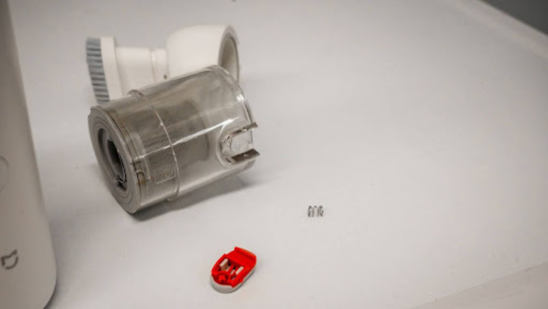 A broken dust cup with its switch and spring detached
