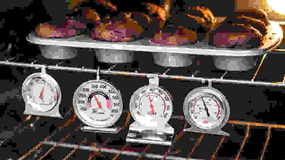 Four of the best oven thermometers Reviewed tested hang inside an oven under a tray of chocolate muffins.