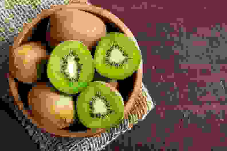 a bowl holding kiwi fruit