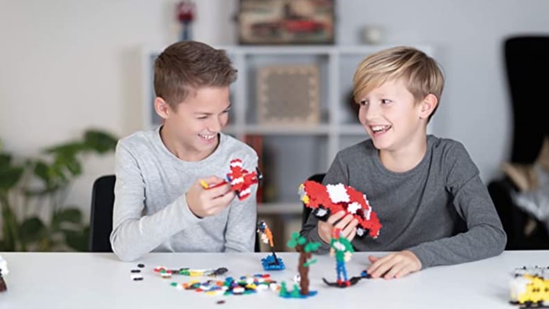 Two kids building with Plus Plus.