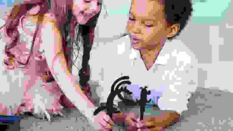Two children with stick character toys together.