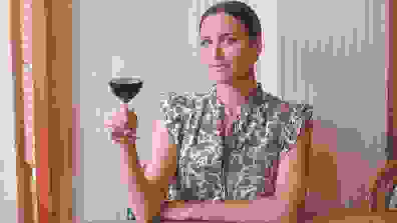 Photo of Marissa Mullen holding a glass of red wine.