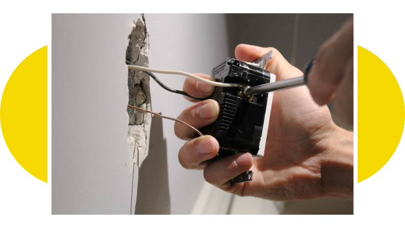 A person's hands installing the smart outlet.