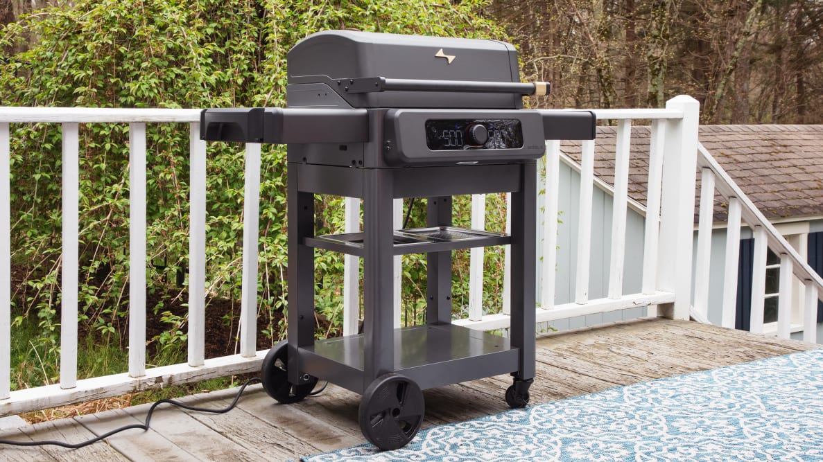 The Current Model G Electric Grill sits on a patio in front of a white railing.