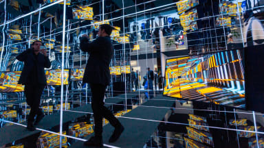 Man taking a picture in a hall of mirrors at CES