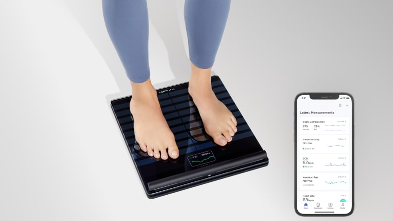 A woman standing on the Withings Body Scan.