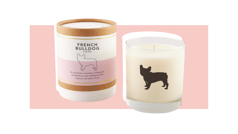 A candle with a french bulldog silhouette against a pink background.