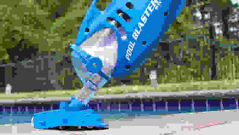 The Water Tech Pool Blaster Max pool cleaner in front of an in-ground pool.
