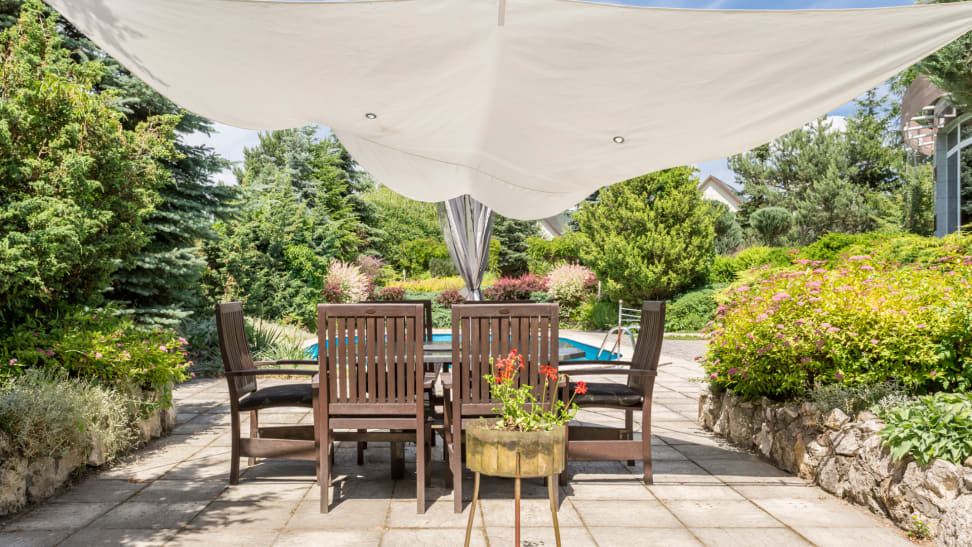 patio with table is covered by a shade sail