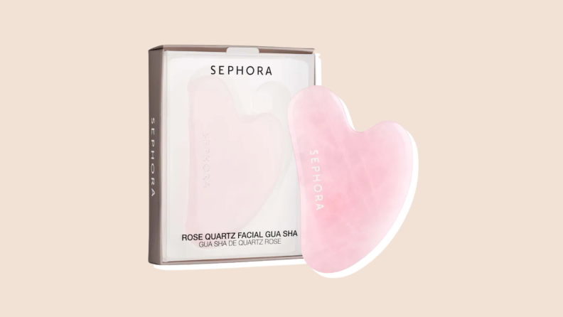 A Pink Sephora Rose Quartz facial Gua Sha and box on a neutral background.