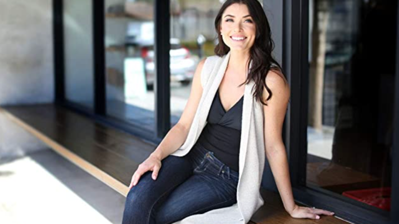 A model sits on an outdoor bench wearing a tanktop made for easy, comfortable breastfeeding.