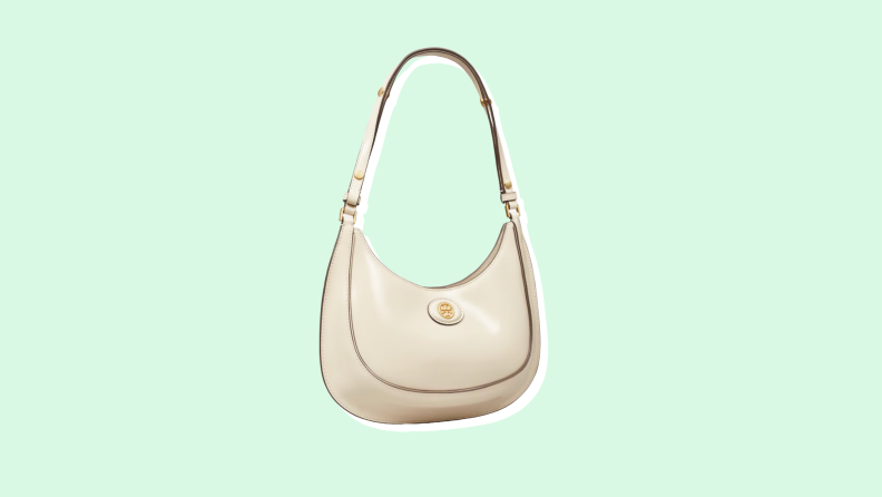 Photo of the Tory Burch Robinson Spazzolato Convertible Crescent Bag against a mint green background.